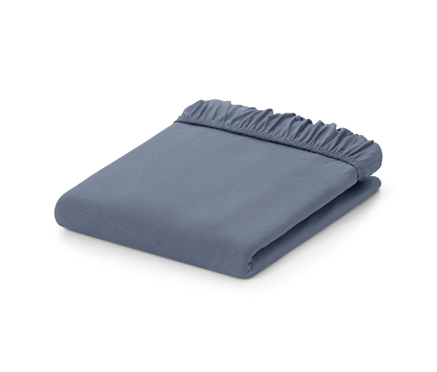 Un drap-housse en jersey bleu, plié.