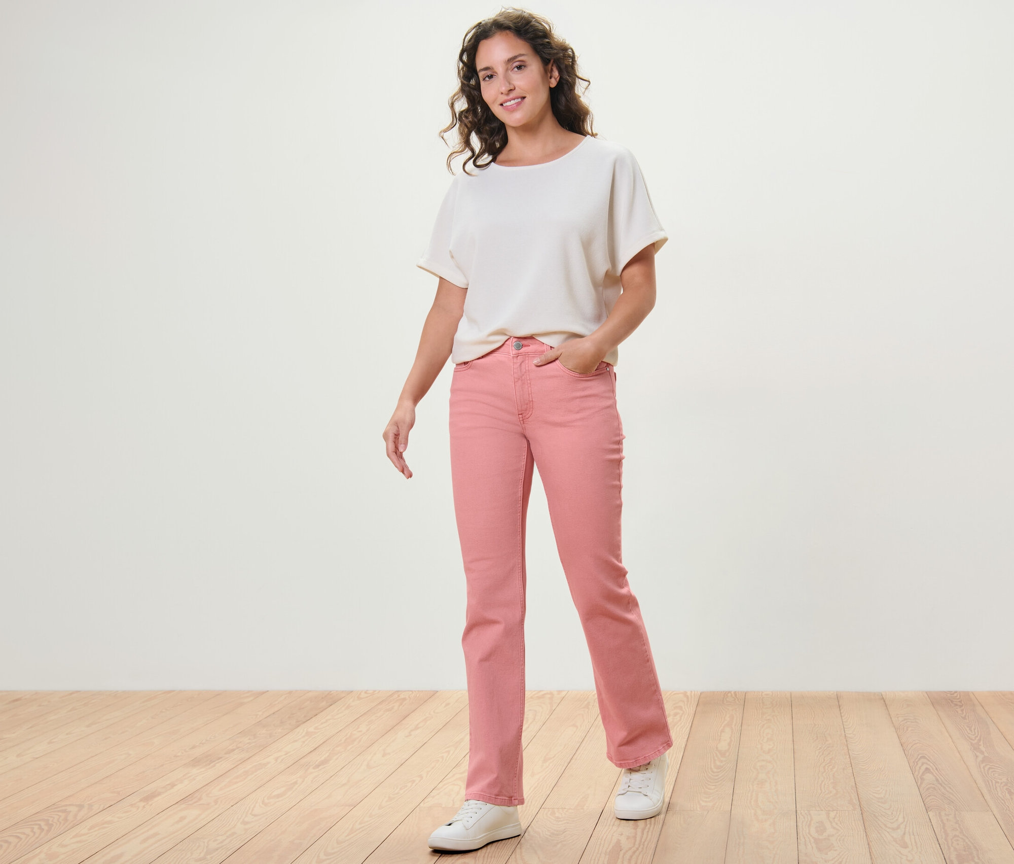 Femme posant en jean bootcut corail Coupe « Lou » et haut blanc.