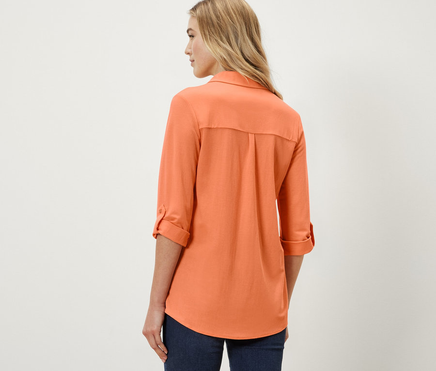 Femme portant un chemisier en jersey piqué, pêche.