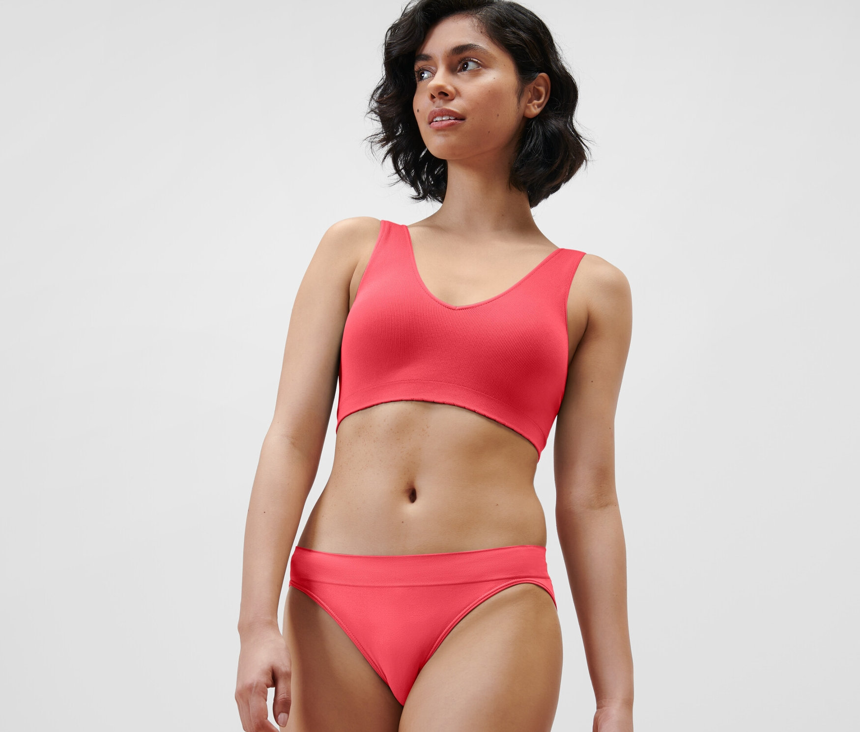 Une femme porte une brassière seamless rouge et une culotte.
