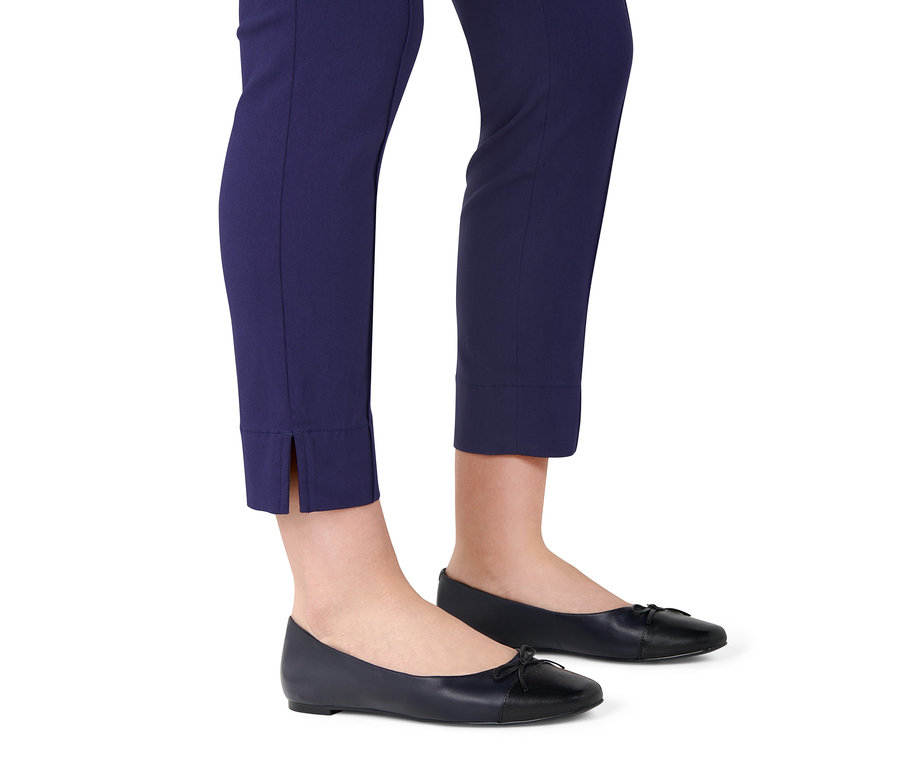 Jambes portant un pantalon bleu marine et des ballerines en cuir bleu marine.