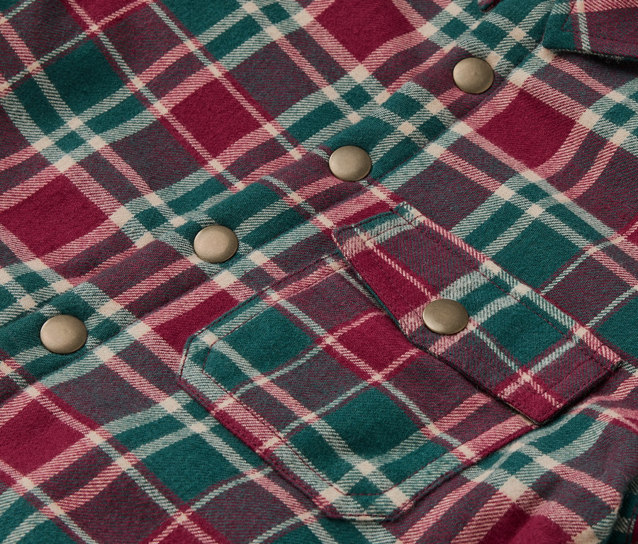 Détail d'une veste en flanelle à carreaux pour enfant avec des boutons-pression.