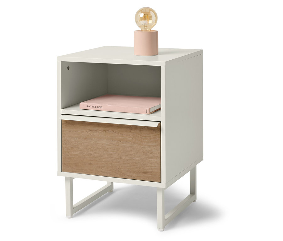 Table de chevet blanche avec tiroir en bois, livre et lampe.