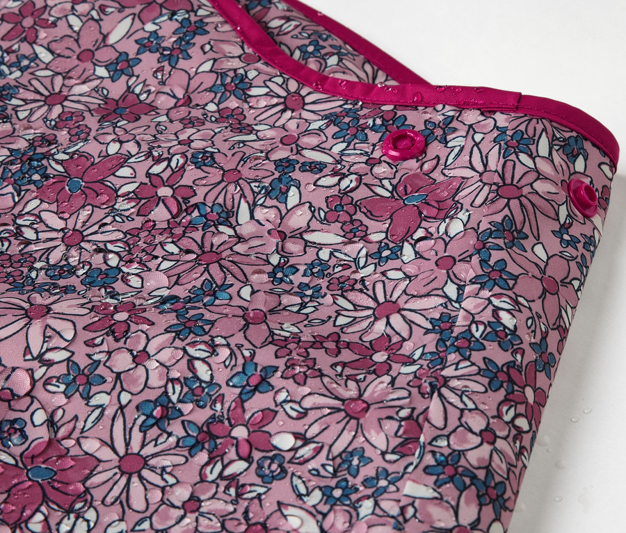 Gros plan sur un pantalon de pluie thermique pour enfant avec un motif floral.