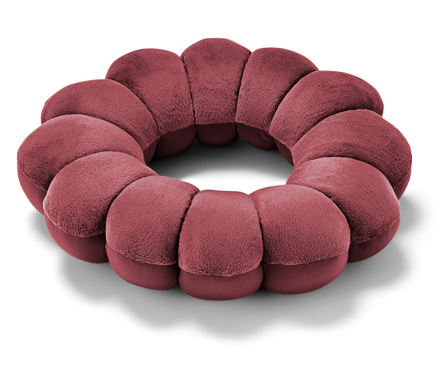 Gros plan d'un coussin circulaire bordeaux.