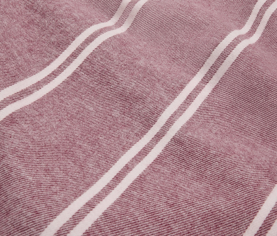 Gros plan sur la texture d'un tissu à rayures bordeaux et blanches.