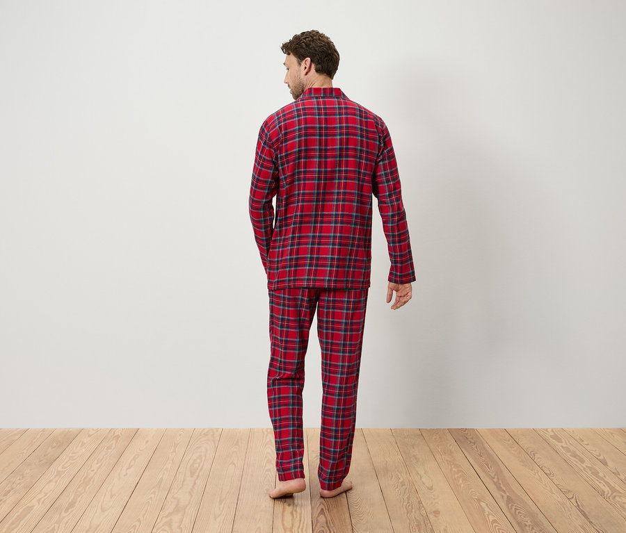 Un homme vu de dos porte un pyjama à carreaux rouges.