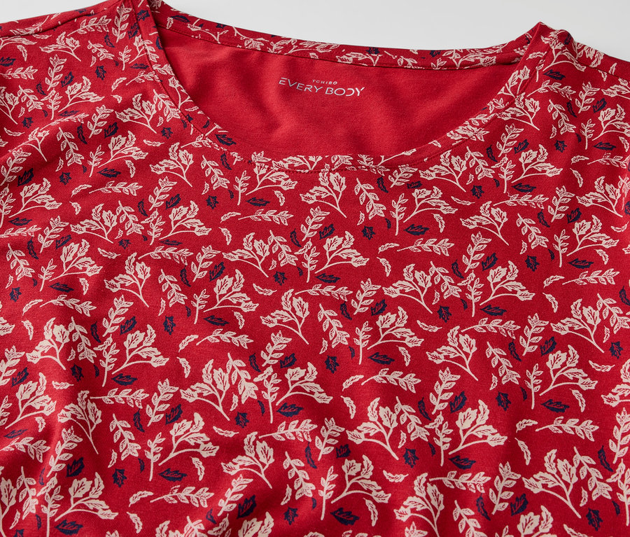 Gros plan d'un t-shirt rouge à motifs de feuilles.
