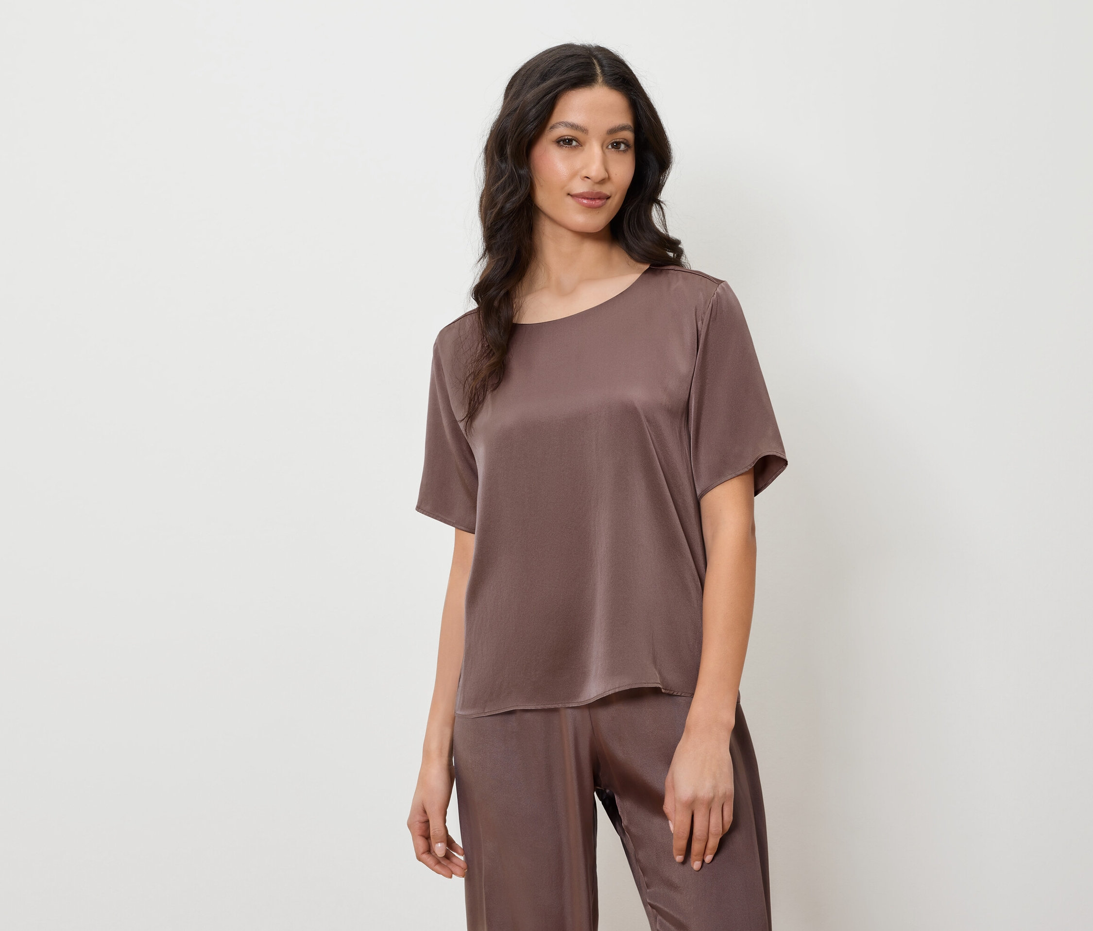 Femme portant un pyjama en satin marron avec des manches courtes et un pantalon.