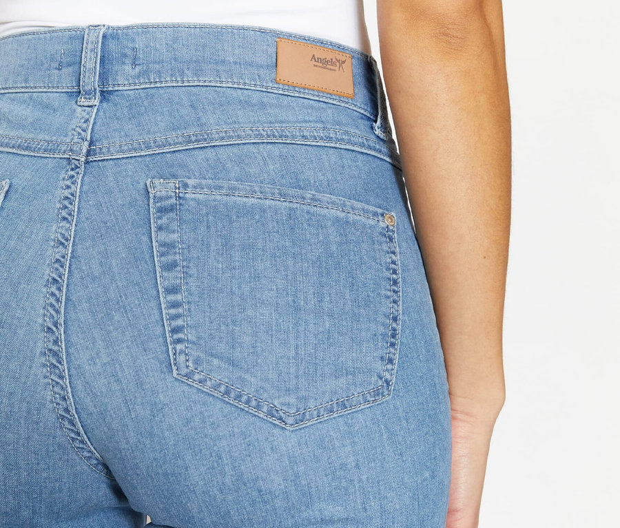Gros plan du dos d'une femme portant un jean « Capri Turn-Up » Angels, coupe étroite, bleu clair.