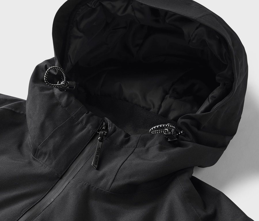 Gros plan sur une veste noire à capuche avec cordon de serrage.