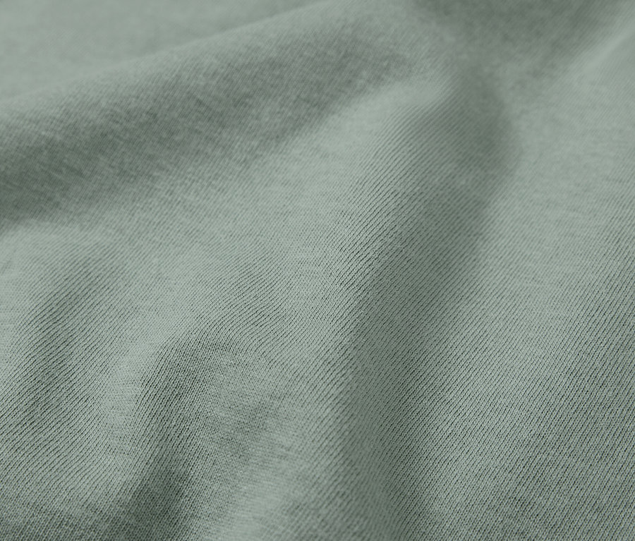 Gros plan d'un tissu vert clair avec des côtes diagonales.