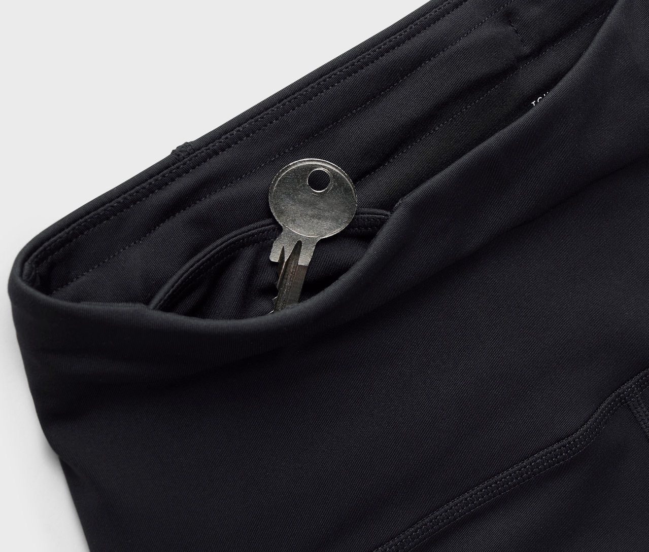 Leggings noires avec une clé dans la poche.