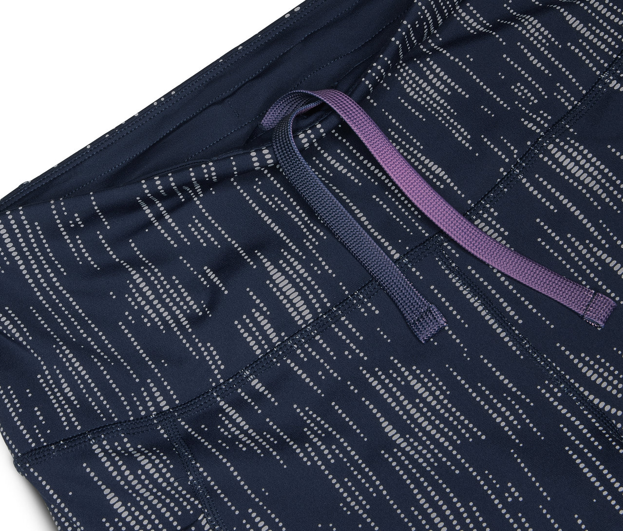 Gros plan sur un short de sport bleu marine avec un motif argenté et un cordon de serrage violet et bleu.