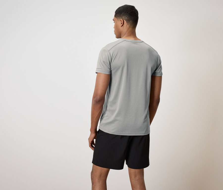 Un homme, vu de dos, porte un t-shirt gris et un short noir.