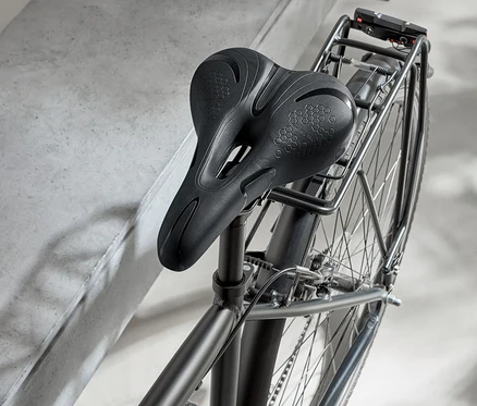 Vélo noir avec selle noire et casque noir sur une surface en béton.
