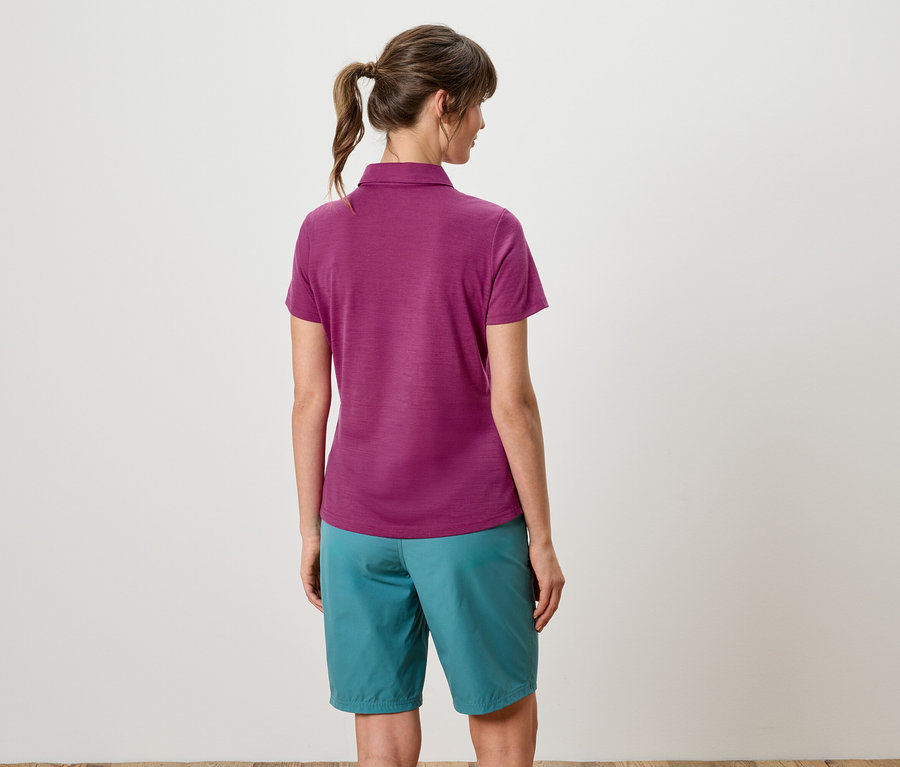 Vue arrière d'une femme avec une queue de cheval portant un polo violet et un short turquoise.