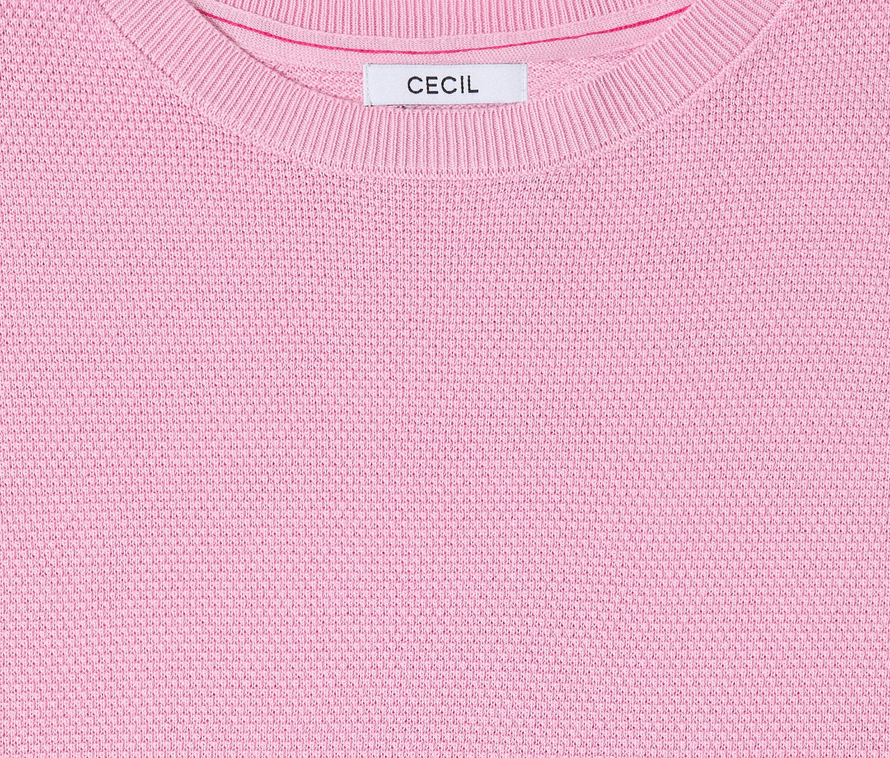 Gros plan sur le pull à manches courtes CECIL rose avec encolure ras du cou et étiquette.