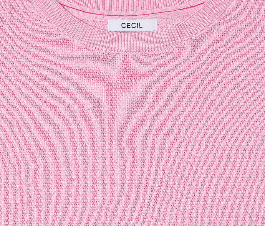 Gros plan sur le pull à manches courtes CECIL rose avec encolure ras du cou et étiquette.