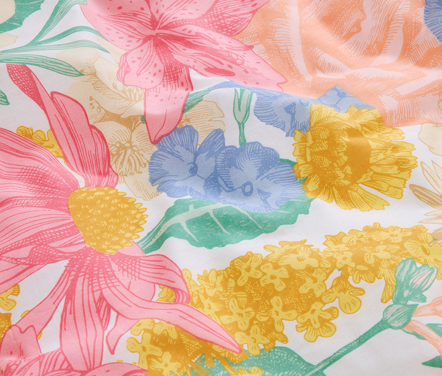 Gros plan sur un tissu à motifs de fleurs roses, jaunes et bleues.