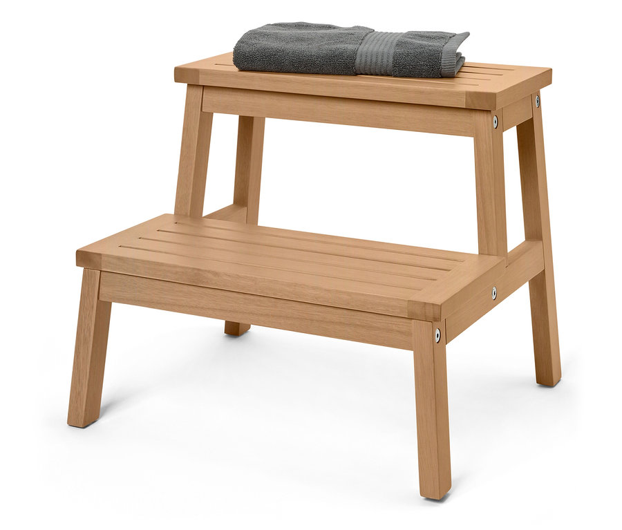Tabouret à deux marches en bois, avec une serviette grise posée sur la marche supérieure.