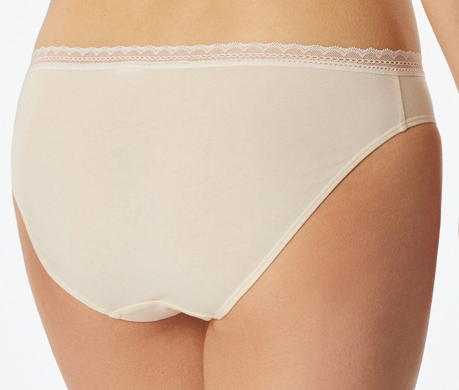 Gros plan du dos d'une femme portant une culotte couleur chair avec des finitions en dentelle.