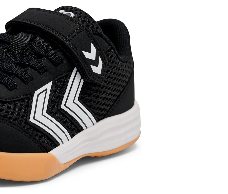 Vue détaillée d'une basket noire avec des rayures blanches et une fermeture velcro.