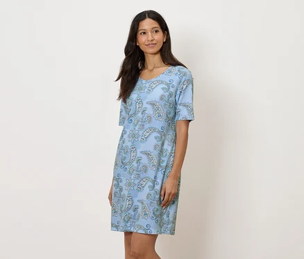 Femme portant une robe bleue à motifs cachemire.