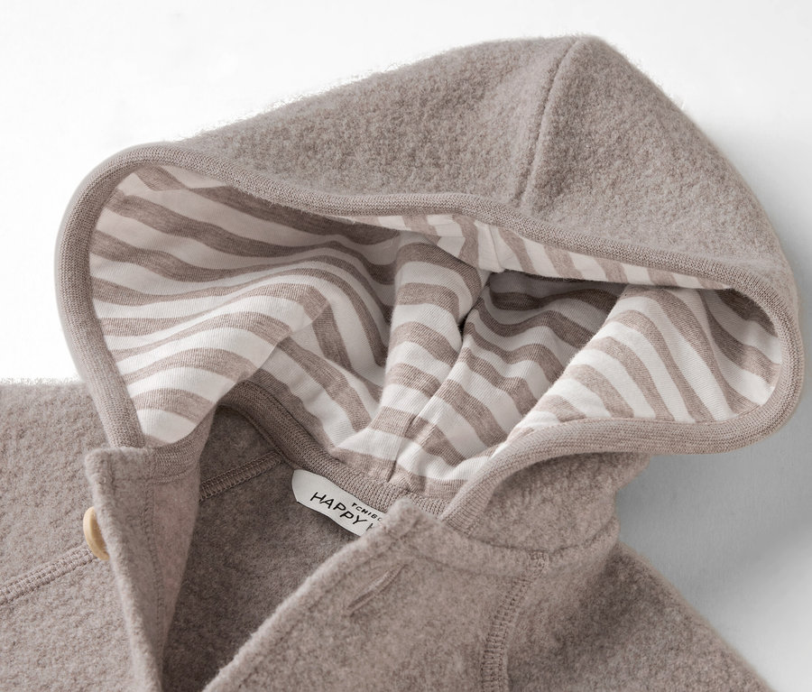 Gros plan d'une capuche en laine polaire beige avec une doublure à rayures beiges et blanches.