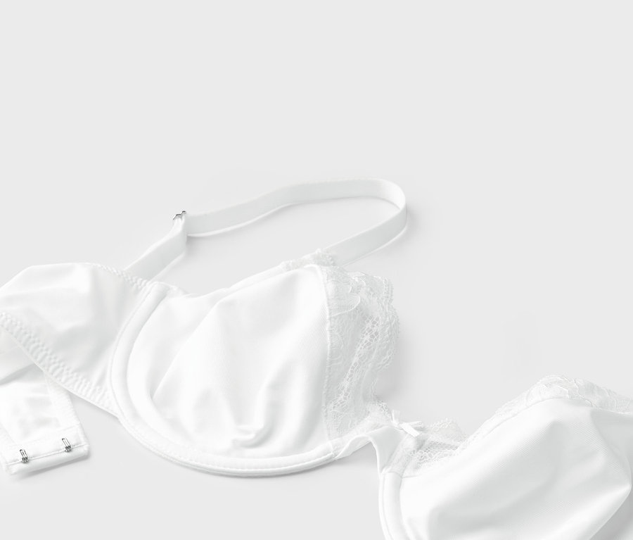 Vue détaillée d'un soutien-gorge blanc à armatures et dentelle sur fond blanc.