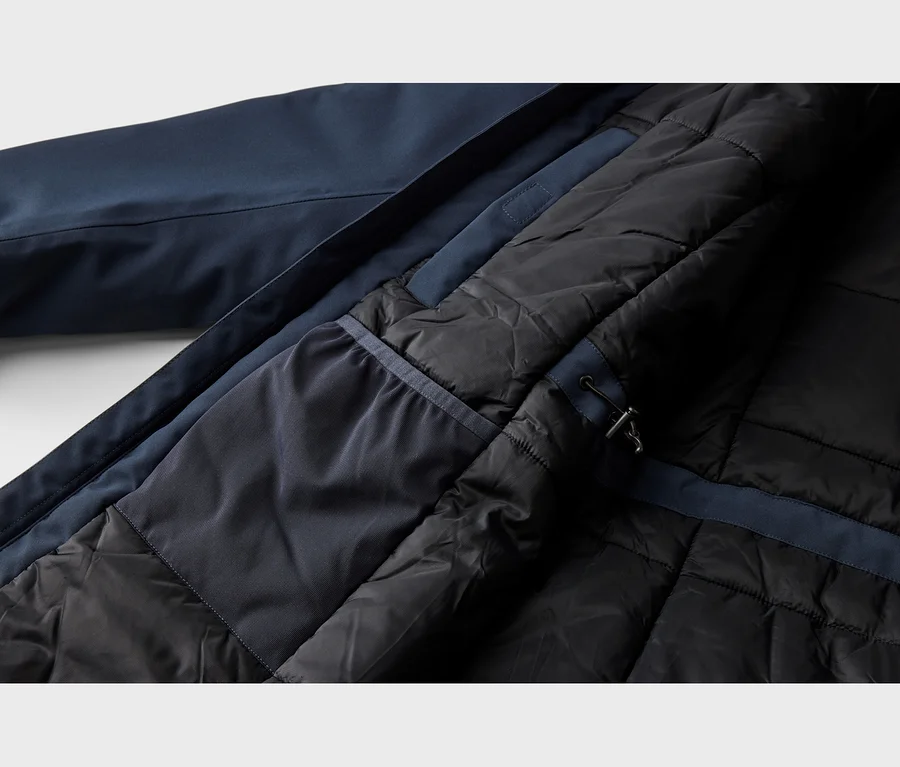 Intérieur d'une veste bleu foncé avec une doublure matelassée noire et un empiècement en tissu bleu foncé avec cordon de serrage.