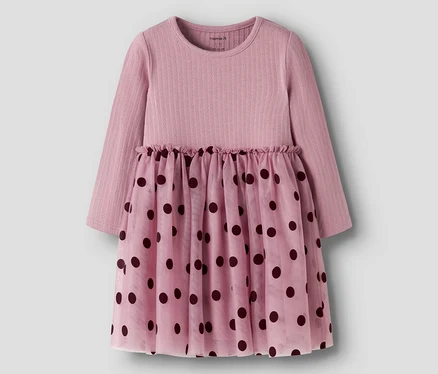 Robe rose à manches longues avec un haut côtelé et une jupe transparente à pois foncés. La taille est froncée.