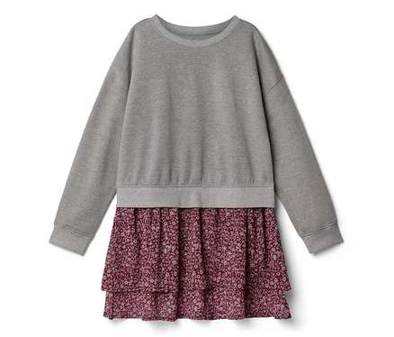 Une robe avec un haut de sweat-shirt gris à manches longues et une jupe bordeaux à volants avec un petit motif floral.