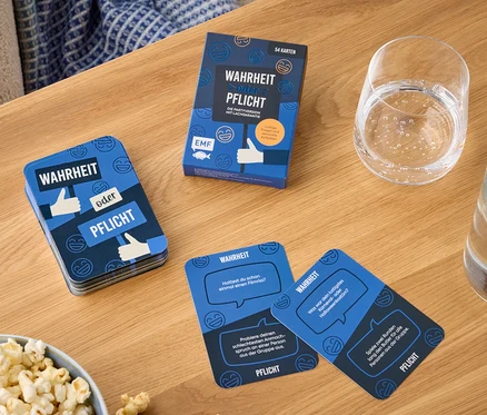 Sur une table en bois se trouvent un bol de pop-corn, un verre d'eau et un paquet de cartes intitulé « Vérité ou Conséquence ».
