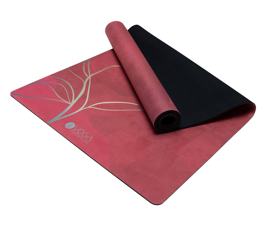 Un tapis de yoga rose partiellement enroulé avec un dessous noir et un imprimé argenté.