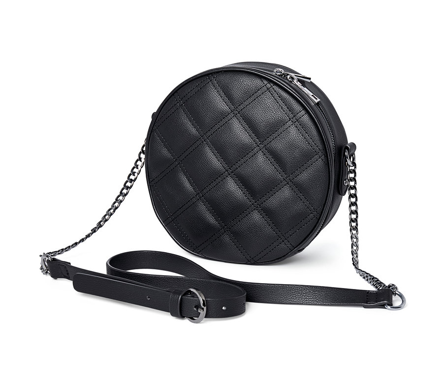 Gros plan d'un sac à bandoulière rond noir avec un motif matelassé.