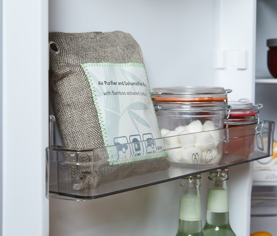 Dans le réfrigérateur, dans un compartiment transparent, un coussin purificateur d’air et absorbeur d’humidité est placé à côté de bocaux avec couvercles.
