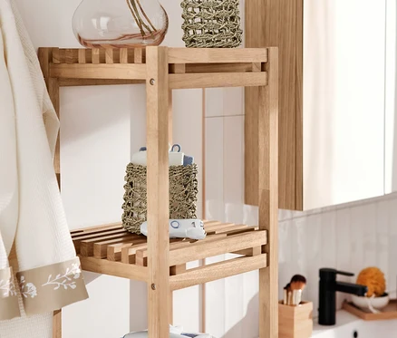 Étagère étroite avec 2 paniers de rangement, linge de bain, épilateur pour le visage et ensemble de voyage sèche-cheveux et fer à lisser.