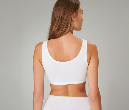 Femme de dos portant une brassière SCHIESSER blanche et un sous-vêtement blanc.