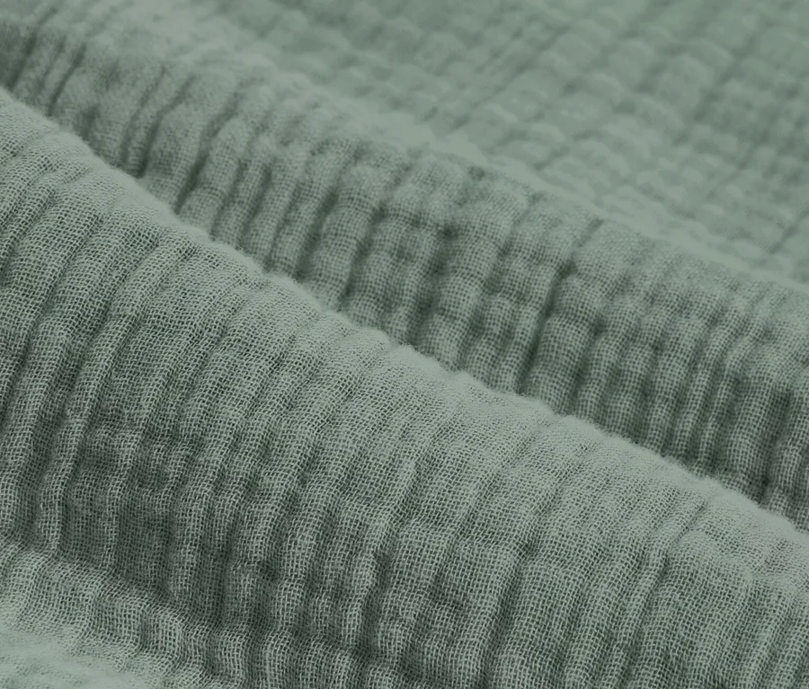 Gros plan d'une parure de lit en mousseline verte de taille standard et grande taille.