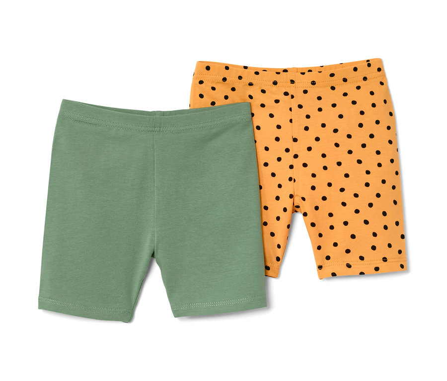 Deux leggings cyclistes pour enfant : un vert et un orange à pois noirs.