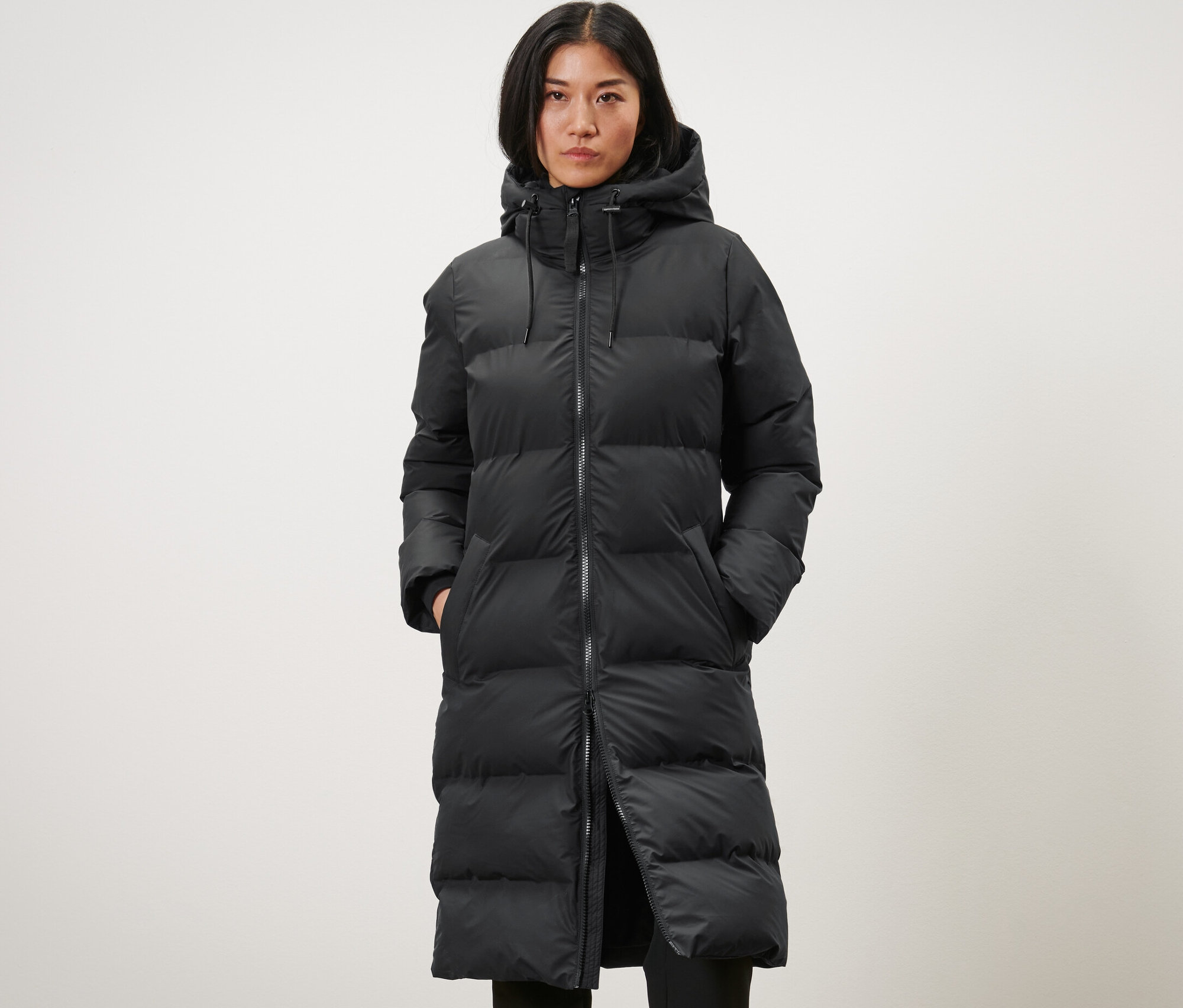 Femme portant un long imperméable d’hiver noir.