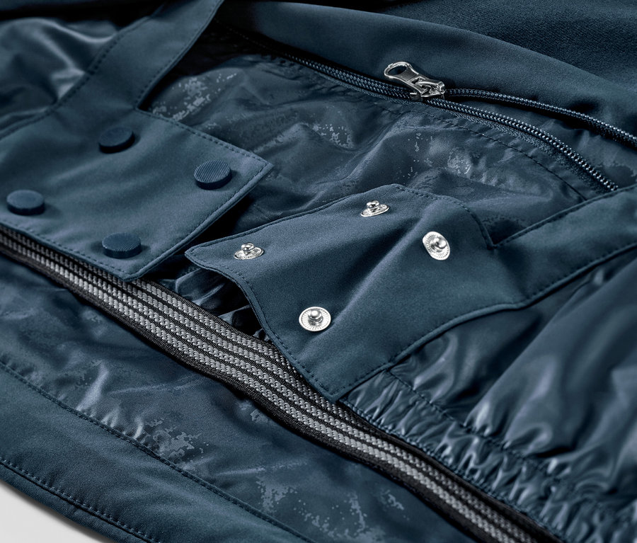 Gros plan sur une veste de ski bleu marine avec fermeture éclair et boutons.