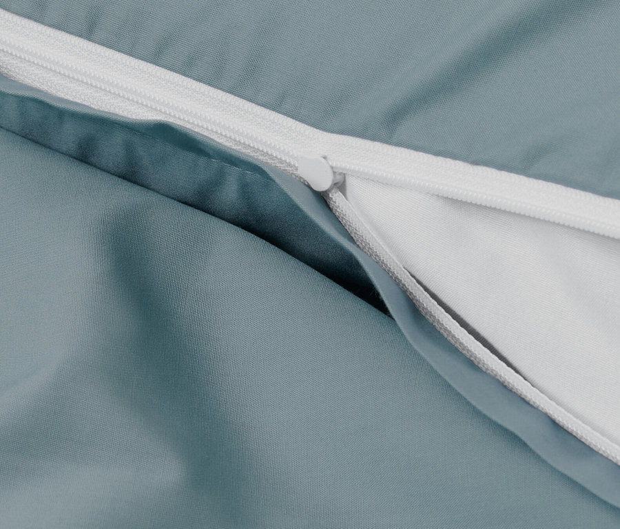 Gros plan d'une parure de lit en percale bleue avec fermeture éclair.
