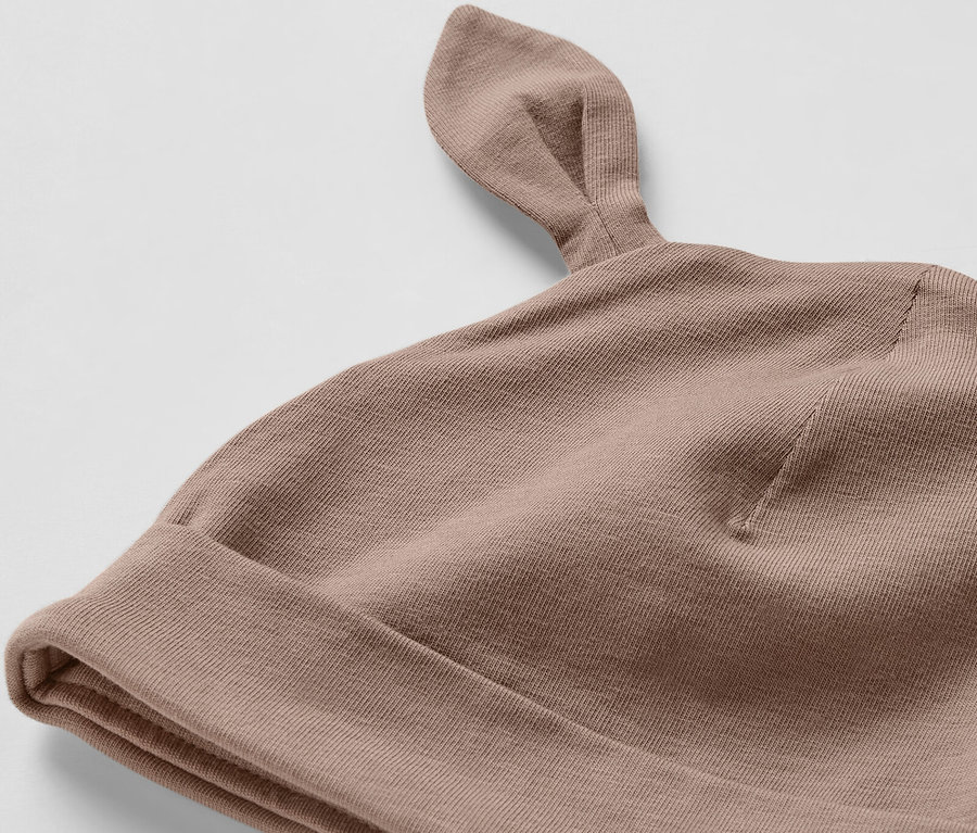Gros plan sur un ensemble pour bébé marron avec des oreilles.