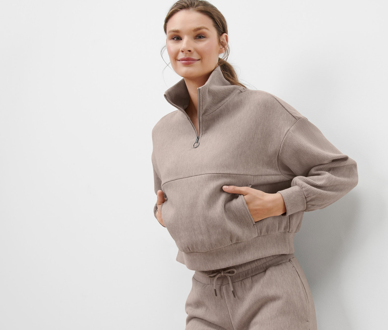 Femme posant dans un pull molletonné beige.