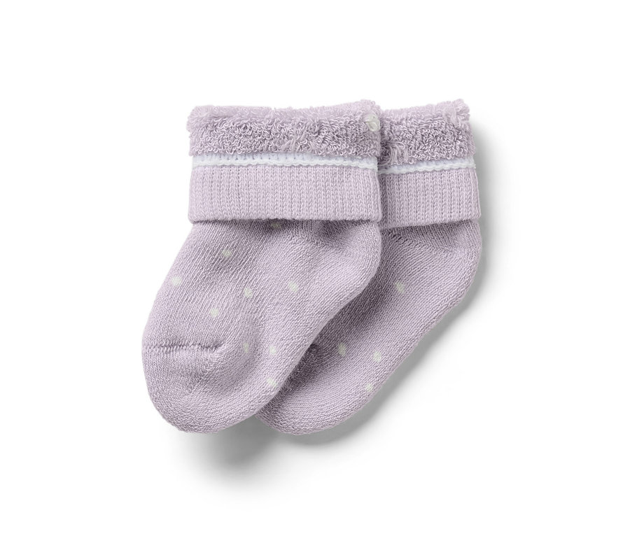 Deux chaussettes lilas pour bébé avec des points blancs.