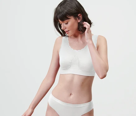 Une femme portant une brassière sans coutures blanche et des sous-vêtements.