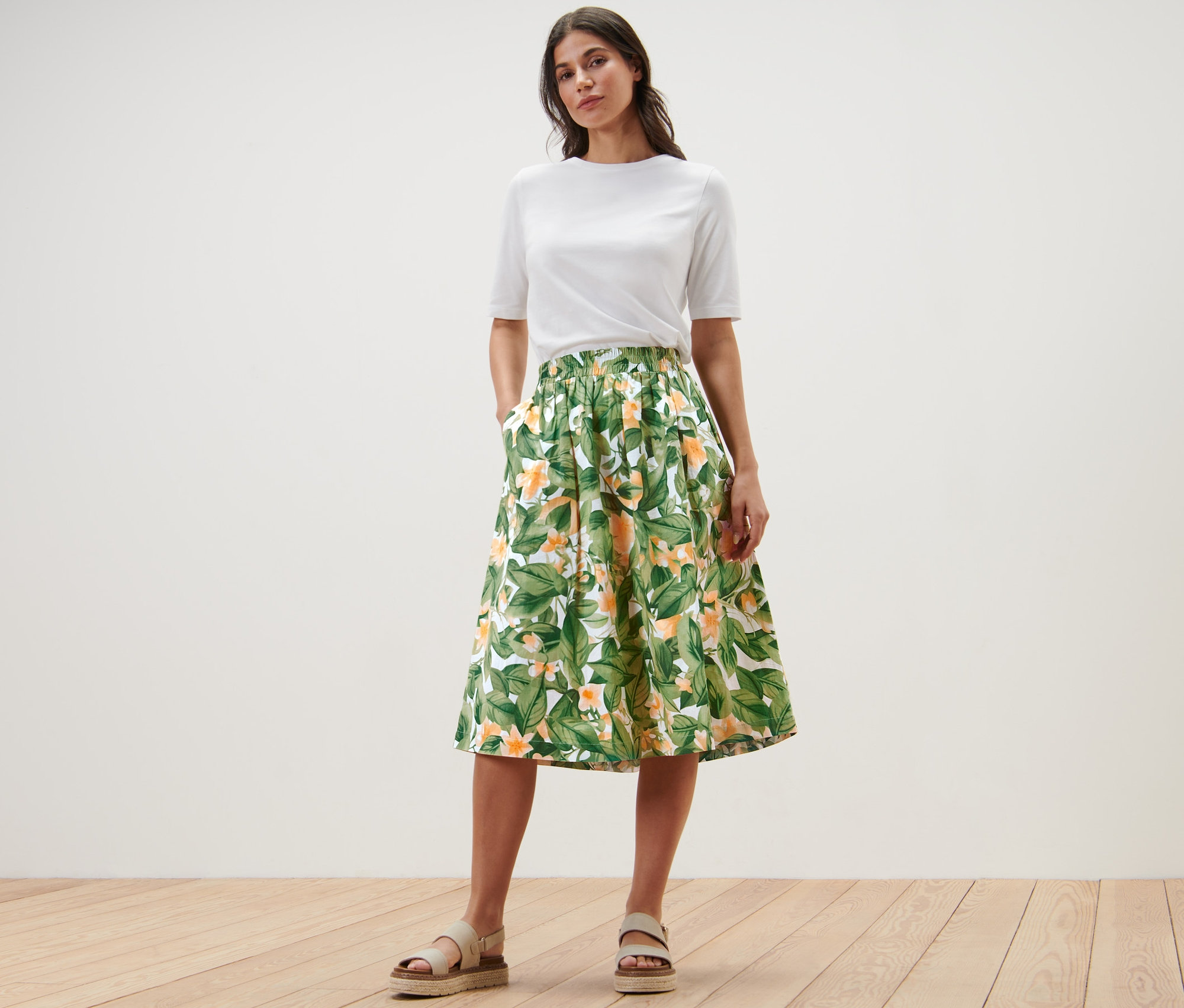 Femme posant en t-shirt blanc et jupe imprimée en popeline.