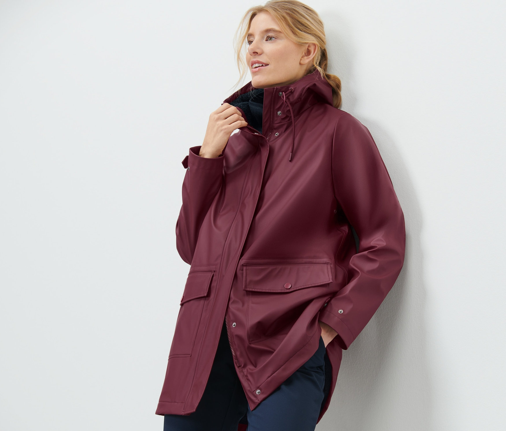 Femme posant dans un manteau de pluie en teddy bordeaux.